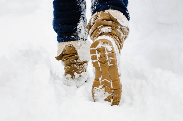 istock Steps along the snow-covered path. A Human walks in the park in the winter. 1369384967