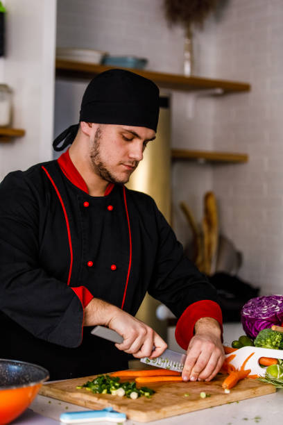 istock Professional chef cutting up carrots and scallions 1369385813