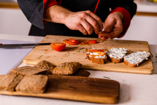 istock Chef arranging tomato slices on sandwiches he is preparing 1369386101
