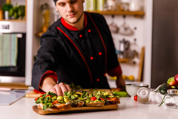 istock Professional chef serving a board with vegan sandwiches he prepared 1369386151