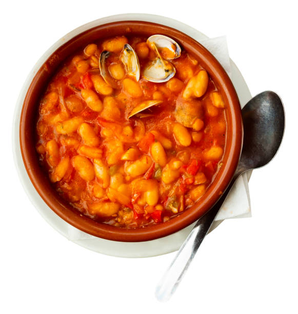Fabes con almejas of white beans stewed with clams in clay bowl Traditional Asturian Fabes con almejas, rich white beans stew with clams seasoned with paprika served in clay bowl. Isolated over white background fabes stock pictures, royalty-free photos & images