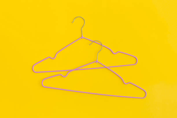 istock Wooden hangers on yellow background. Top view. Flat lay. 1369386971