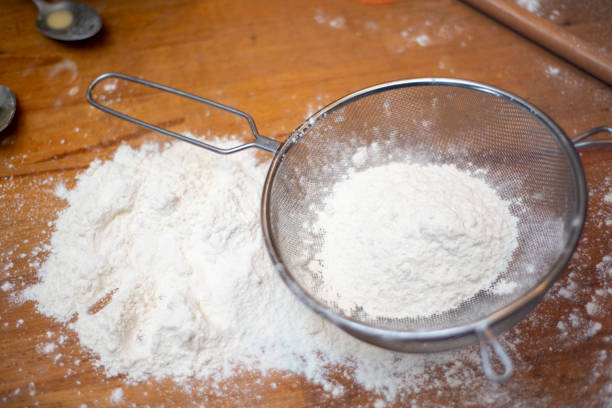 istock Flour sieve standing on flour on brown table. 1369389310
