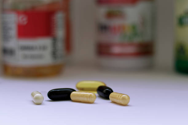 красочные таблетки перед флаконами - vitamin a vitamin b complex pill bottle medicine стоковые фото и изображения