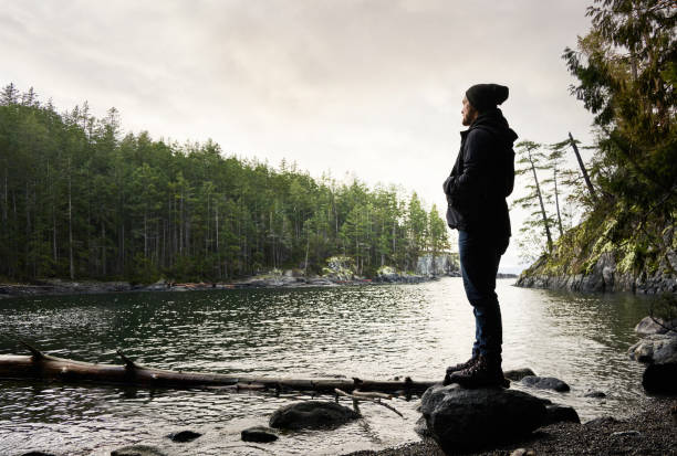 istock Man standing by a rocky inlet during a hike along the coast 1369391065