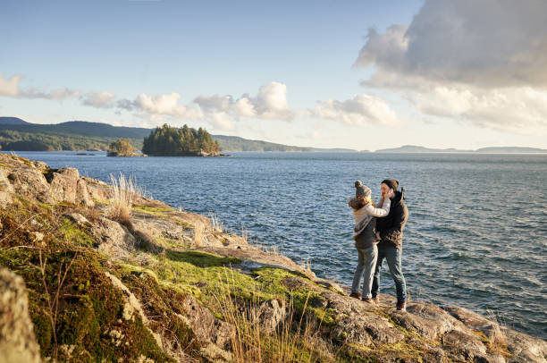 Couple standing together by a rocky coast during a hike