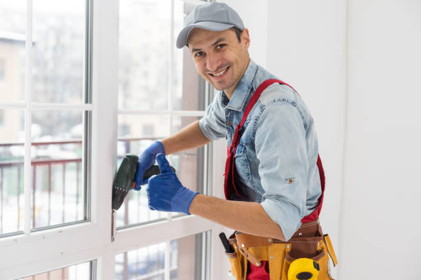 istock Construction worker installing window in house. Handyman fixing the window with screwdriver 1369391332