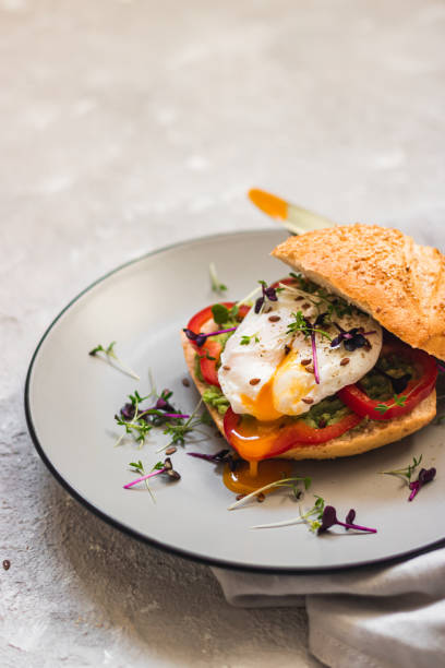 istock Poached egg on a bun with avocado, bell pepper and micro green on a gray plate. Healthy breakfast. Brunch idea. Clean eating. vegetarian. protein source food 1369392965