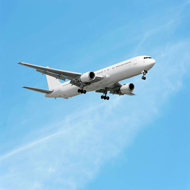 istock XL jet airplane landing in bright sky 136939488