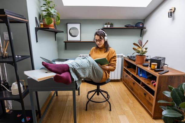 Beautiful young woman working from home Beautiful young woman feeling cozy while working from home legs crossed at ankle stock pictures, royalty-free photos & images