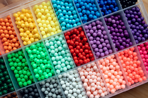 colorful beads in the container with cells. set for creativity and needlework. Convenient storage of beads.
