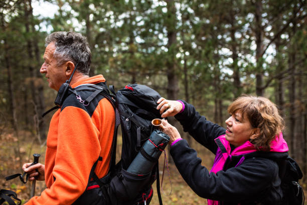 istock A mature woman taking something out of her partner's backpack while hiking 1369398304