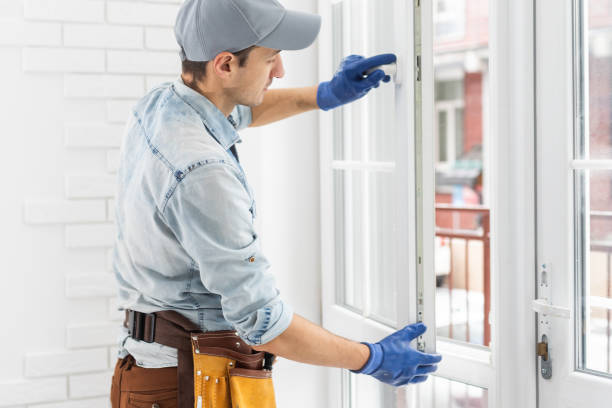 istock Construction worker putting sealing foam tape on window in house 1369399683