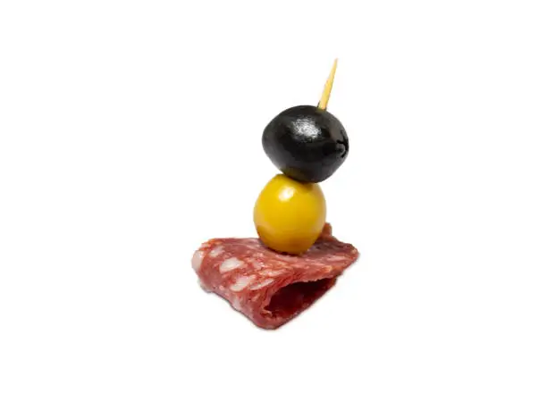 Slicing salami and olives on toothpicks."nKanape. Slicing on a kitchen board