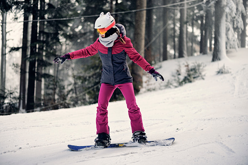 Teenage girl enjoying snowboarding on a winter day.
Canon R5