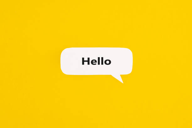 黄色の背景に「こんにちは」という言葉が付いている紙の吹き出し。コピースペースのあるトップビュー。フラットレイ。 - label sign symbol single word ストックフォトと画像