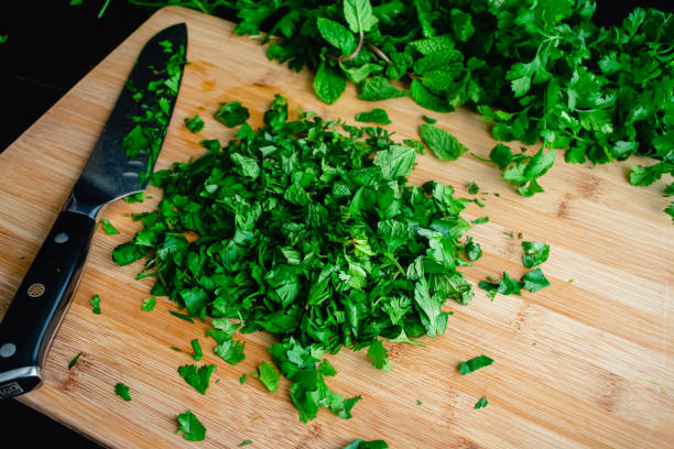 kuvapankkikuvat ja rojaltivapaat kuvat aiheesta hienonnetut tuoreet yrtit bambu-leikkuulaudalla - flat leaf parsley