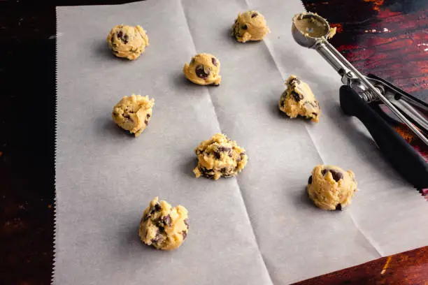 Raw cookie dough on a parchment paper lined sheet pan