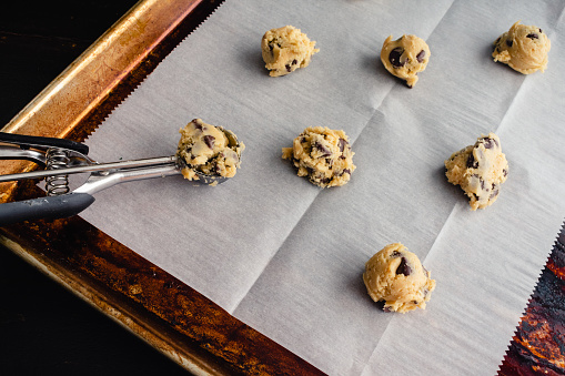 Raw cookie dough on a parchment paper lined sheet pan