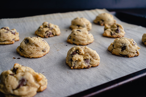 Chocolate chip cookies on a sheet pan lined with parchment paper