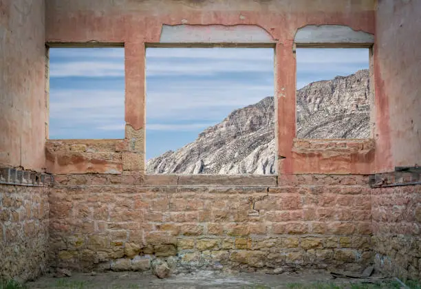 rocky cliff view through windows of a ruined ghost town building