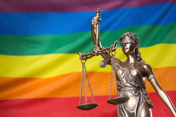 the blindfolded goddess of justice themis or justitia against the rainbow flag of lgbt community, as a lgbt social issues concept - gay pride flag fotos imagens e fotografias de stock