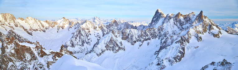 The mountain Aiguille du Midi 3842 meters in the Mont Blanc massif in the French Alps at sunset, panoramic image, peaks of mountains. High quality photo