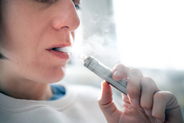 Young woman with e-cigarette - vaping Close up shot of a young woman using electronic cigarettes electronic cigarette stock pictures, royalty-free photos & images