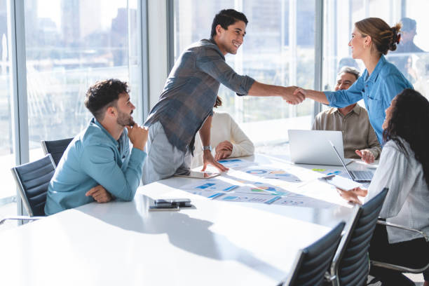istock Man and woman shaking hands during a meeting. 1369408413