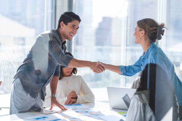 istock Man and woman shaking hands during a meeting. 1369408419