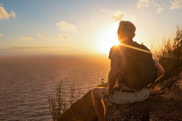 hombre excursionista viendo el hermoso amanecer desde la cima de la montaña. - sun watch fotografías e imágenes de stock