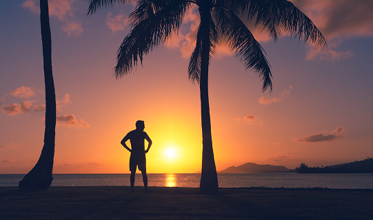 Man standing and watching beautiful sunset in Hawaii.