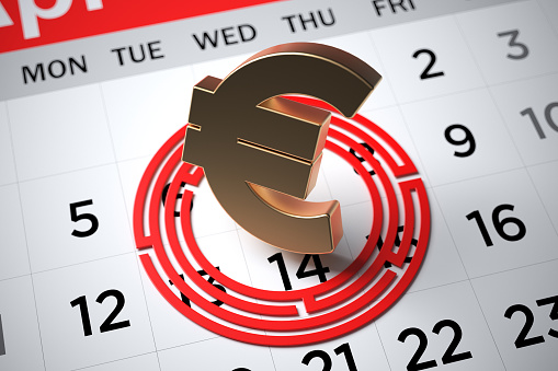Golden euro symbol and red-colored maze. On the white calendar page. Horizontal composition with copy space. Focused image.