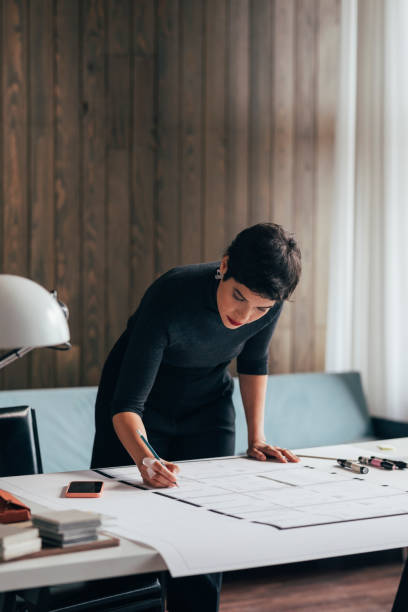 istock Devoted Female Architect Working on an Architectural Drawing of a Building 1369414827