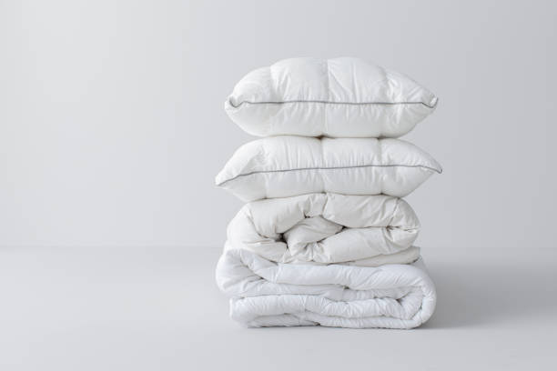 istock Folded White Linen and Pillows Isolated on a Grey Background 1369415812