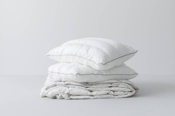 istock Folded White Linen and Pillows Isolated on a Grey Background 1369415818