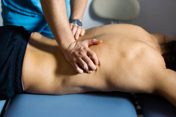 istock Close up of Physical Therapist Massaging Lower Back (Close Up) 1369417431