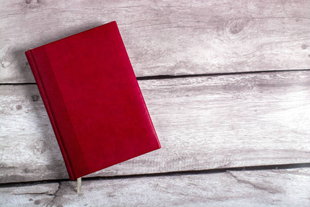 istock diary made of red leather on a wooden background. 1369418679
