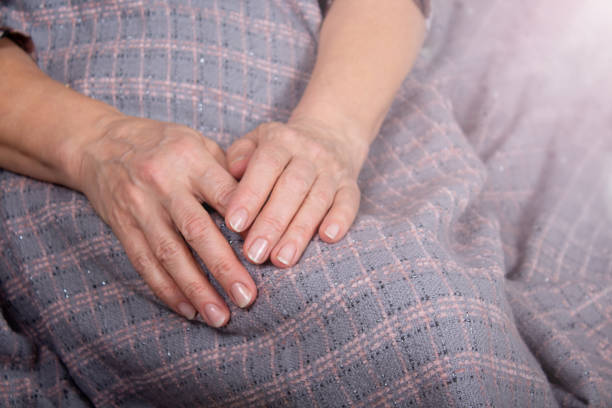 istock Old woman's hands rest over the plaid 1369418686