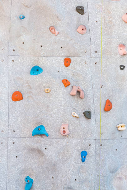 istock Grey wall with climbing holds and ropes in gym 1369418940