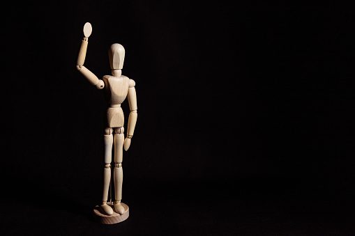 Wooden mannequin informer holding his hand up. Report to reply or goodbye symbol
