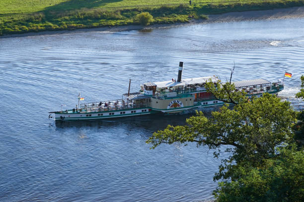 Dresden, Saxony, Germany - Oktober 09 2021: The paddle steamer 'Pirna' of the Sächsische Dampfschifffahrt seen from a vineyard. Dresden has the oldest and largest fleet of active paddle steamers.