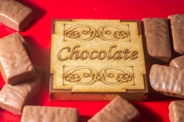 istock chocolate box written with chocolate bars on the side, red background, copy space and selective focus on the box, valentine s day, 1369420645