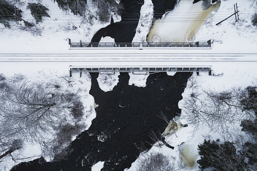 Aerial view of a railway bridge over a small river during an intense ice storm.