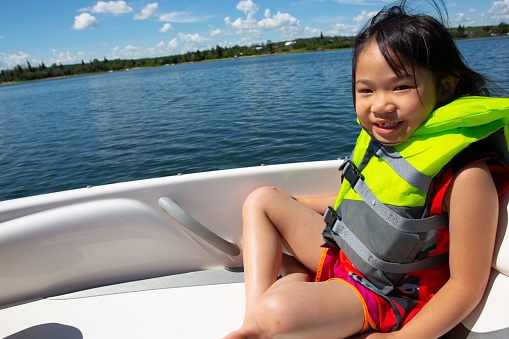 happy little asian enjoying her boat ride
