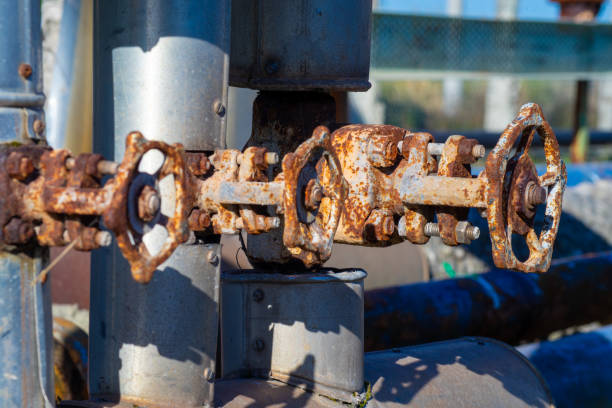 istock four old and rusty industrial liquid control faucets.  One in each tube aligned parallel with differentiated focus. 1369430457