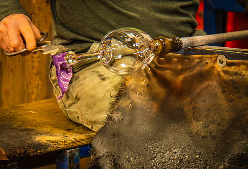 glass blower shaping a glass goblet