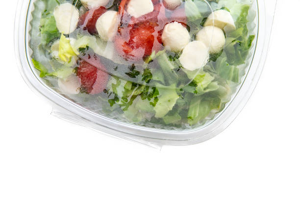 Italian salad in a plastic container, with letucce, cherry tomato, and mozzarella cheese