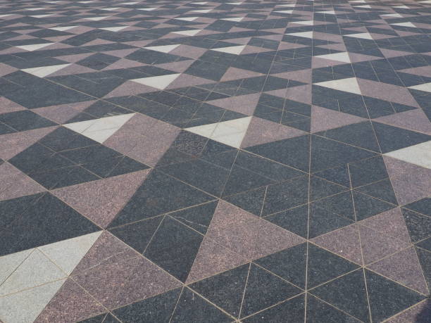 istock The square is paved with triangular tiles. Grey, white, black tiles on the street. The cobblestone surface. Modern design of streets, avenues, squares, shopping centers. Wear-resistant flooring. 1369437649