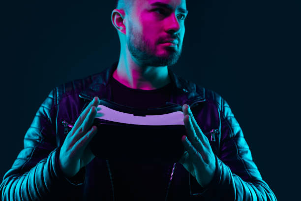 istock Serious man with VR headset in neon lights 1369437898